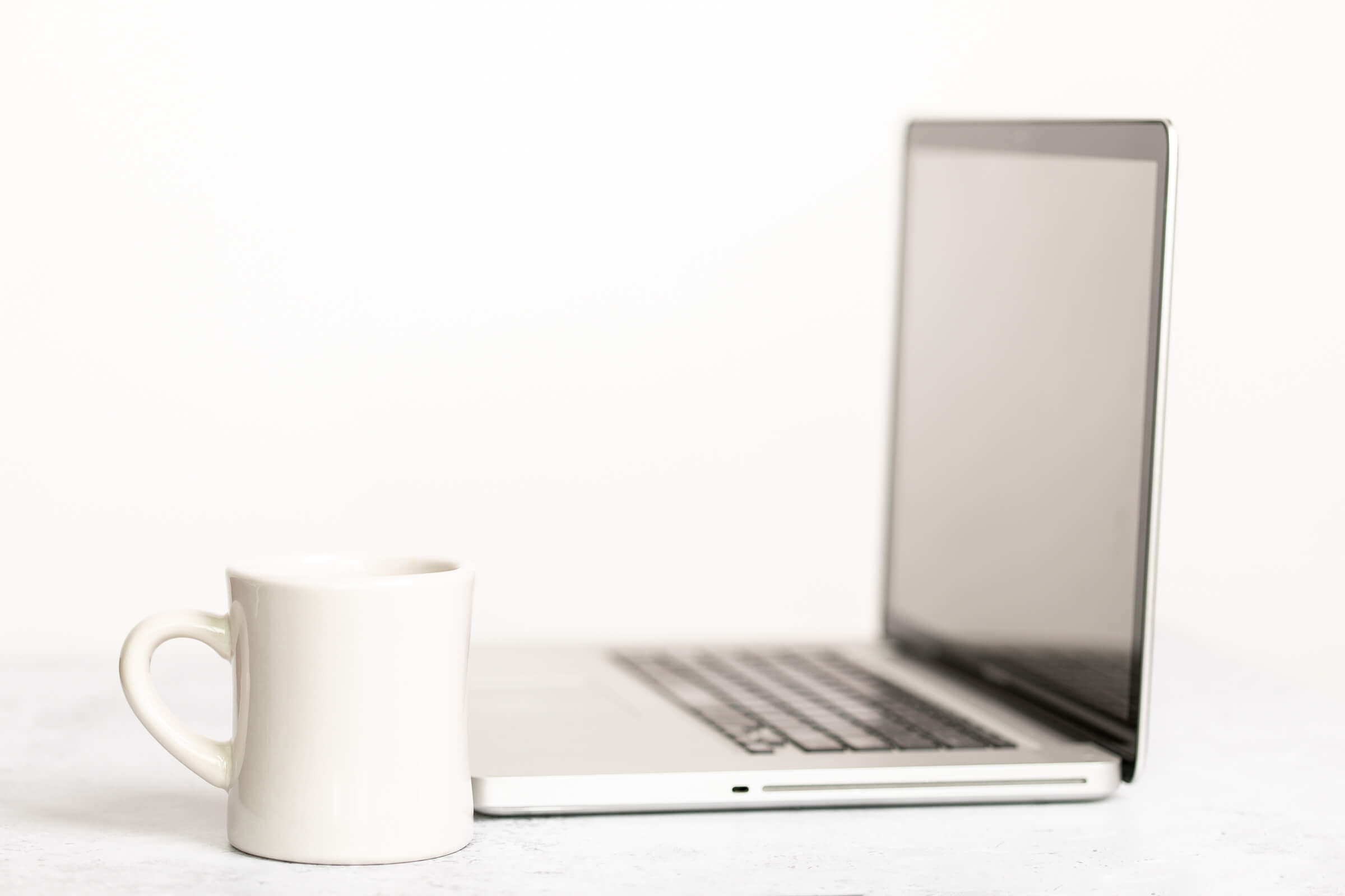 Win more clients as a Facebook Ads manager - laptop with a white mug